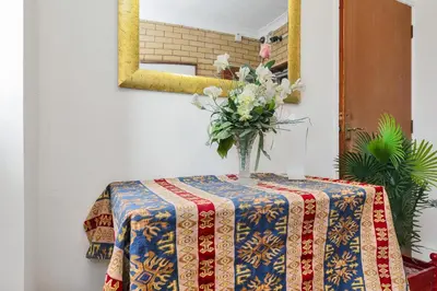 a vase of flowers on a table with a mirror at Shelford Lodge in Cambridge