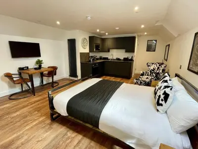 a hotel room with a large bed and a kitchen at Booking Urban at Stisted in Braintree