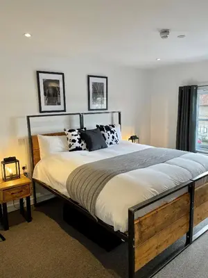 a bedroom with a large bed with black and white pillows at Booking Urban at Stisted in Braintree
