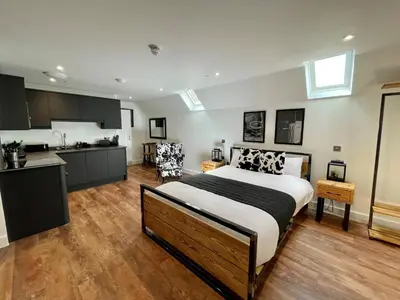 a bedroom with a large bed and a kitchen at Booking Urban at Stisted in Braintree