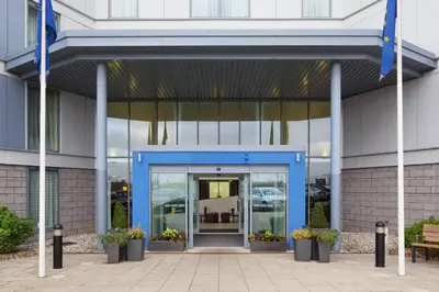 an entrance to a building with a blue door at Holiday Inn Express London Stansted Airport by IHG in Stansted Mountfitchet