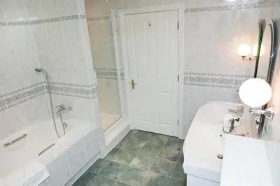 a bathroom with a tub and a toilet and a sink at Marygreen Manor in Brentwood