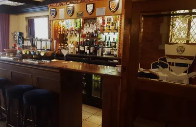 a bar with a lot of bottles of alcohol at Marygreen Manor in Brentwood