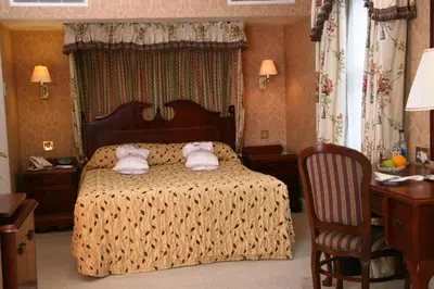 a bedroom with a bed with two towels on it at Marygreen Manor in Brentwood