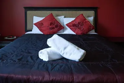 a bed with two towels and pillows on it at Desalis Hotel London Stansted in Elsenham