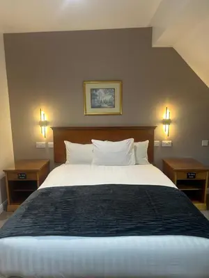 a bedroom with a large bed with two night stands at Desalis Hotel London Stansted in Elsenham