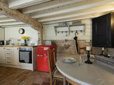 a kitchen with a table and a red refrigerator at The Dairy - Ukc1546 in Heveningham