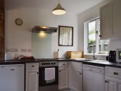 a kitchen with white cabinets and a stove top oven at Millers Rest in Willingham