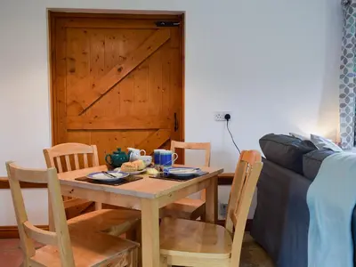 a dining room table and chairs with a wooden door at Millers Rest in Willingham