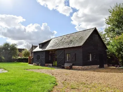 a black house sitting on top of a green field at Millers Rest in Willingham