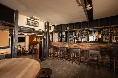 a bar with a bunch of bar stools at The Cock Inn Hotel in Sheering