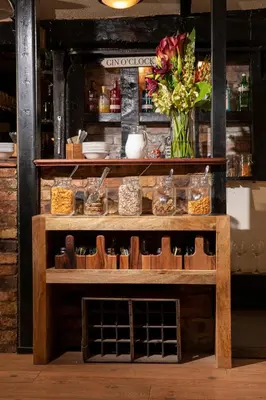 a wooden table with a vase of flowers on it at The Cock Inn Hotel in Sheering
