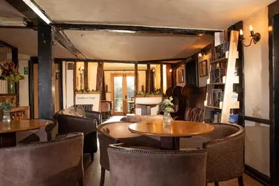 a restaurant with tables and chairs in a room at The Cock Inn Hotel in Sheering