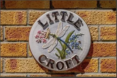a clock on the side of a brick wall at Little Croft in Haddenham