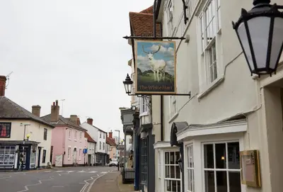 a sign on the side of a building on a street at White Hart Hotel by Greene King Inns in Coggeshall
