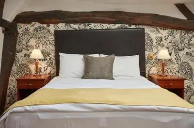 a bedroom with a large bed with two lamps at White Hart Hotel by Greene King Inns in Coggeshall