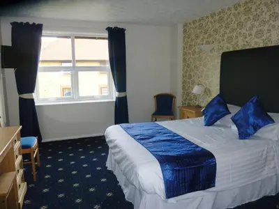 a hotel room with a bed and a window at The Oakland Hotel in Woodham Ferrers