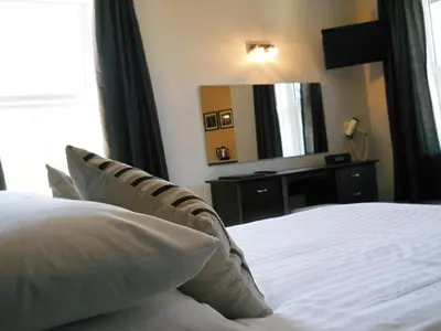 a bedroom with a white bed and a large mirror at The Oakland Hotel in Woodham Ferrers