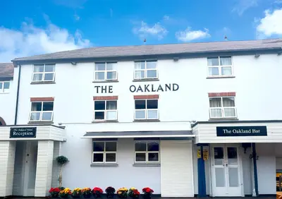 a white building with the oakland sign on it at The Oakland Hotel in Woodham Ferrers