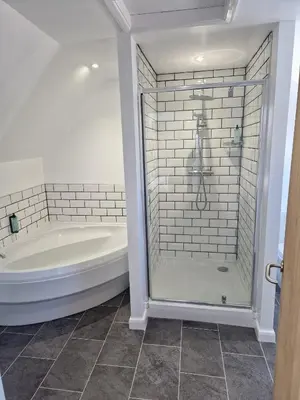a white bathroom with a tub and a shower at The Riverside House Hotel in Mildenhall