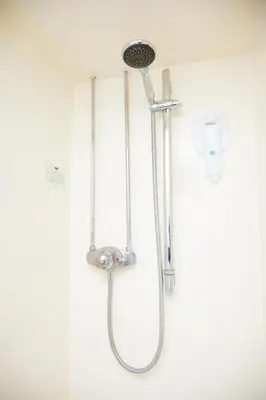 a shower with a shower head on a wall at Bull Hotel by Greene King Inns in Halstead