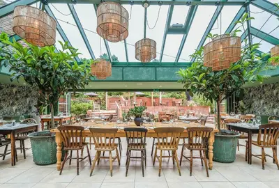 a restaurant with tables and chairs and potted plants at The Westleton Crown in Westleton