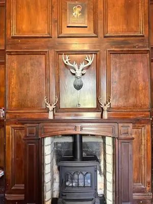 a fireplace with a deer head above it at Broom Hall Country Hotel in Saham Toney