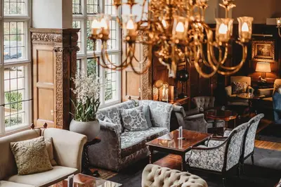 a living room with furniture and a chandelier at Greenwoods Hotel & Spa in Stock