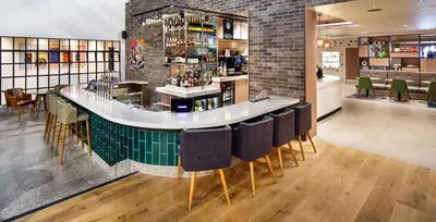 a bar with black chairs and a brick wall at Holiday Inn Brentwood by IHG in Brentwood