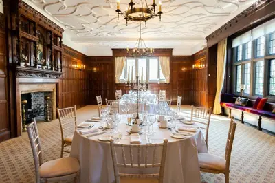 a dining room with a table with chairs and a chandelier at Fanhams Hall, Exclusive Collection in Ware
