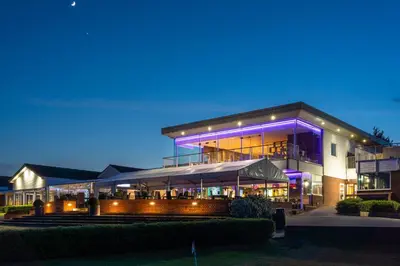 a building with a lit up facade at night at Stoke By Nayland Hotel, Golf & Spa in Leavenheath