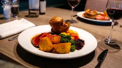 a plate of food on a table with wine glasses at Stoke By Nayland Hotel, Golf & Spa in Leavenheath