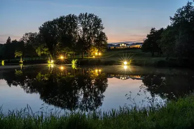 a view of a lake at night with lights at Stoke By Nayland Hotel, Golf & Spa in Leavenheath