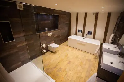 a bathroom with a shower and a toilet and a sink at Channels Hotel in Chelmsford