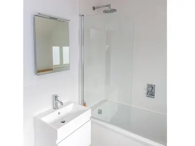 a white bathroom with a sink and a shower at Laurel Studio in Aldeburgh