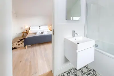 a bedroom with a bed and a sink and a mirror at Laurel Studio in Aldeburgh