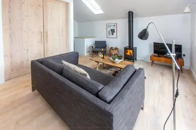 a living room with a couch and a fireplace at Laurel Studio in Aldeburgh