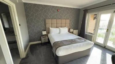 a bedroom with a large bed and a bathroom at Dolphin Hotel St Ives in St Ives