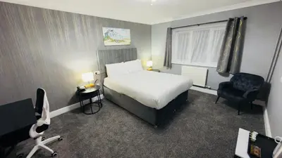 a hotel room with a bed and a chair at Dolphin Hotel St Ives in St Ives