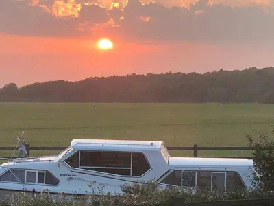 a boat parked in a field with the sunset in the background at Dolphin Hotel St Ives in St Ives