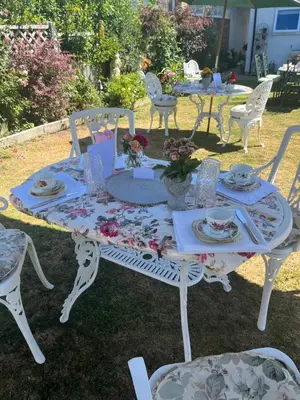a white table with chairs and a table with plates and dishes at Southend Airport Bed & Breakfast in Rochford