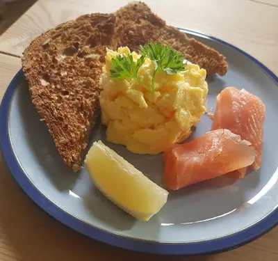 a plate of food with eggs and toast and a slice of lemon at Belle Vue Guest House in Denver