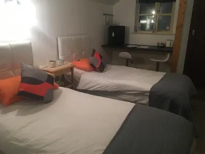 a hotel room with two beds and a table at Woodland Lodge in Hoddesdon