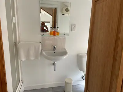 a white bathroom with a sink and a toilet at Woodland Lodge in Hoddesdon