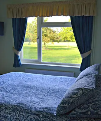 a bedroom with a bed and a window at Little Bullocks Farm in Takeley