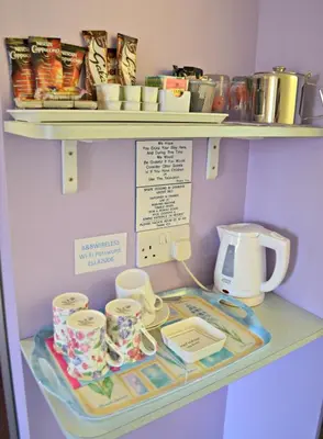 a shelf with cups and other items on it at Little Bullocks Farm in Takeley