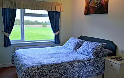 a bedroom with a bed and a window at Little Bullocks Farm in Takeley