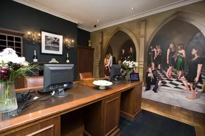 a lobby with a desk with a computer and a group of people at Hotel du Vin & Bistro Cambridge in Cambridge