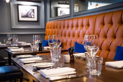 a row of tables in a restaurant with wine glasses at Hotel du Vin & Bistro Cambridge in Cambridge