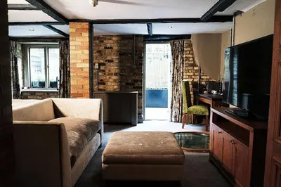 a living room with a couch and a tv at Hotel du Vin & Bistro Cambridge in Cambridge